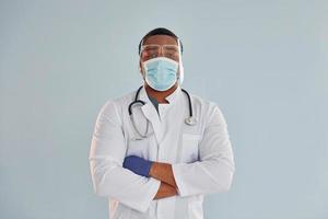 African american doctor in white coat is standing indoors photo