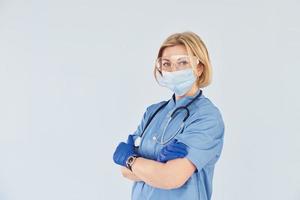 Middle-aged professional female doctor in uniform and with stethoscope photo