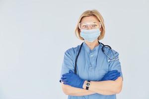 Middle-aged professional female doctor in uniform and with stethoscope photo