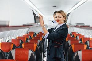 joven azafata con mayordomo en el trabajo en el avión de pasajeros foto