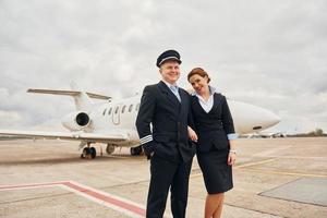 Man with woman. Aircraft crew in work uniform is together outdoors near plane photo