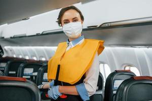 Safety instructions. Young stewardess on the work in the passanger airplane photo