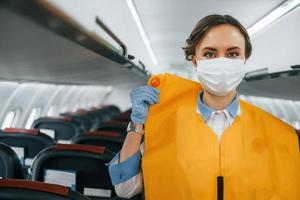 Safety instructions. Young stewardess on the work in the passanger airplane photo