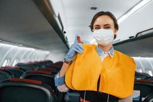 Safety instructions. Young stewardess on the work in the passanger airplane photo