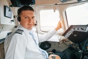 Pilot on the work in the passenger airplane. Preparing for takeoff photo