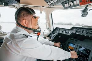 In oxygen mask. Pilot on the work in the passenger airplane. Preparing for takeoff photo