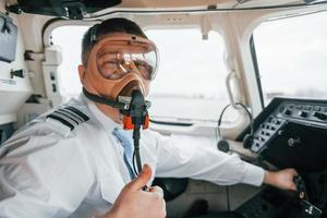 In oxygen mask. Pilot on the work in the passenger airplane. Preparing for takeoff photo