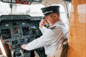 piloto en el trabajo en el avión de pasajeros. preparándose para el despegue foto