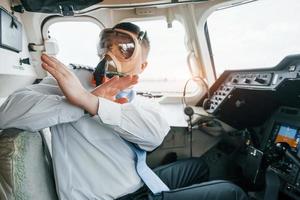 en máscara de oxígeno. piloto en el trabajo en el avión de pasajeros. preparándose para el despegue foto