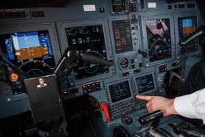 vista de cerca piloto en el trabajo en el avión de pasajeros. preparándose para el despegue foto