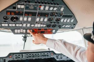 vista de cerca piloto en el trabajo en el avión de pasajeros. preparándose para el despegue foto