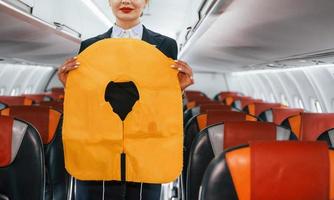 Safety instructions. Young stewardess on the work in the passanger airplane photo