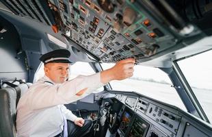 control del vuelo. piloto en el trabajo en el avión de pasajeros. preparándose para el despegue foto