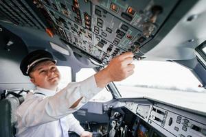 Control of the flight. Pilot on the work in the passenger airplane. Preparing for takeoff photo