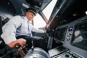 Pilot on the work in the passenger airplane. Preparing for takeoff photo