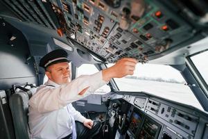 control del vuelo. piloto en el trabajo en el avión de pasajeros. preparándose para el despegue foto