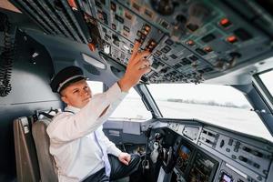 control del vuelo. piloto en el trabajo en el avión de pasajeros. preparándose para el despegue foto