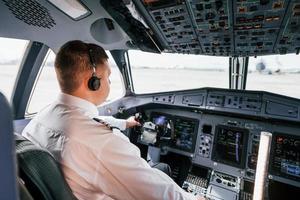 piloto en el trabajo en el avión de pasajeros. preparándose para el despegue foto