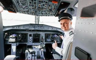 Looks behind. Pilot on the work in the passenger airplane. Preparing for takeoff photo