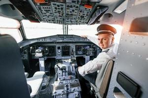 Looks behind. Pilot on the work in the passenger airplane. Preparing for takeoff photo