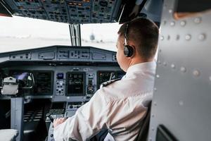 Pilot on the work in the passenger airplane. Preparing for takeoff photo