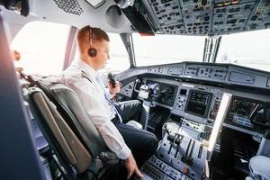 Pilot on the work in the passenger airplane. Preparing for takeoff photo