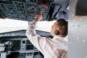 control del vuelo. piloto en el trabajo en el avión de pasajeros. preparándose para el despegue foto