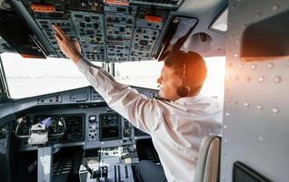 control del vuelo. piloto en el trabajo en el avión de pasajeros. preparándose para el despegue foto