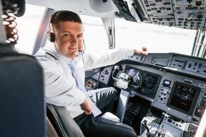 Pilot on the work in the passenger airplane. Preparing for takeoff photo