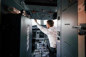 control del vuelo. piloto en el trabajo en el avión de pasajeros. preparándose para el despegue foto