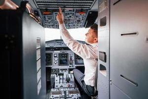 Control of the flight. Pilot on the work in the passenger airplane. Preparing for takeoff photo