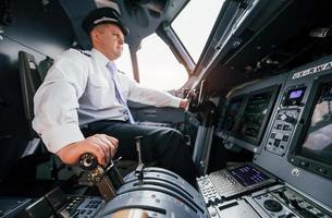 piloto en el trabajo en el avión de pasajeros. preparándose para el despegue foto