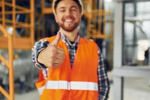 Portrait of construction worker in uniform is in the factory photo