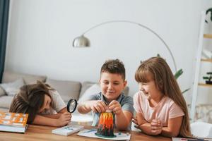 Working on the volcano project. Kids having fun in the domestic room at daytime together photo