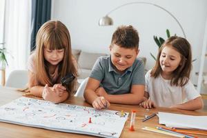 Playing game together. Kids having fun in the domestic room at daytime photo