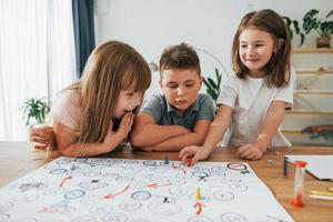 Playing game together. Kids having fun in the domestic room at daytime photo