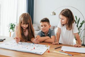 Playing game together. Kids having fun in the domestic room at daytime photo