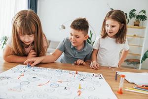 Playing game together. Kids having fun in the domestic room at daytime photo