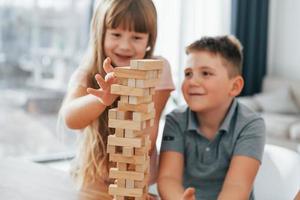 construyendo una torre. jugando un juego. niños divirtiéndose juntos en la sala doméstica durante el día foto