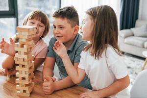 construyendo una torre. jugando un juego. niños divirtiéndose juntos en la sala doméstica durante el día foto