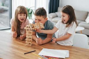 construyendo una torre. jugando un juego. niños divirtiéndose juntos en la sala doméstica durante el día foto