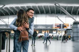 feliz pareja joven está en el aeropuerto juntos foto