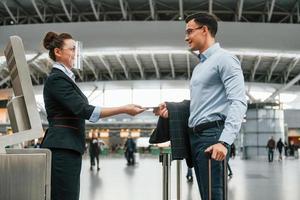 comprobación de documentos. un joven hombre de negocios con ropa formal está en el aeropuerto durante el día foto