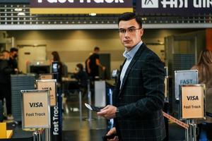 fondo moderno. un joven hombre de negocios con ropa formal está en el aeropuerto durante el día foto