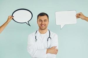 In doctor's uniform. Man standing in the studio with empty signs for the text photo