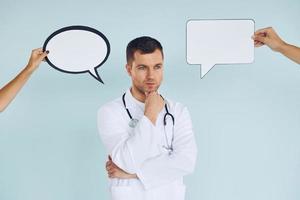 In doctor's uniform. Man standing in the studio with empty signs for the text photo