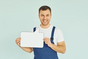 trabajador diciendo algo. hombre de pie en el estudio con carteles vacíos para el texto foto