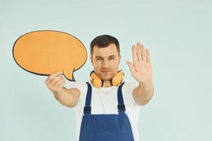 With big headphones on neck. Man standing in the studio with empty signs for the text photo