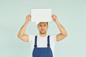 trabajador diciendo algo. hombre de pie en el estudio con carteles vacíos para el texto foto