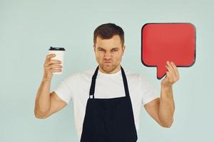 Angry and holding drink in hand. Man standing in the studio with empty signs for the text photo